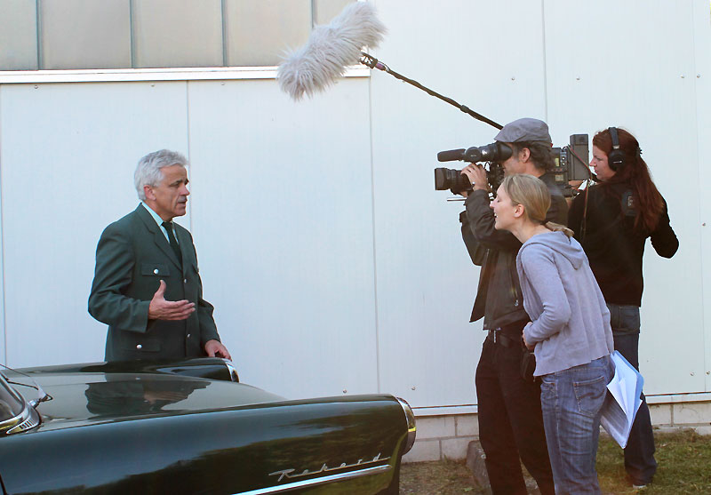 Museums-Pressesprecher Eberhard Dersch gibt dem HR-Team ein Interview vor dem Polizei-Opel Olympia P1