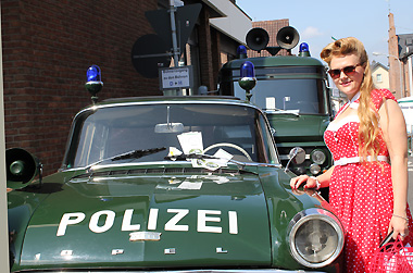 Polizei-Opel mit Dame im entsprechenen Golden Oldies-Outfit mit Petticoat 