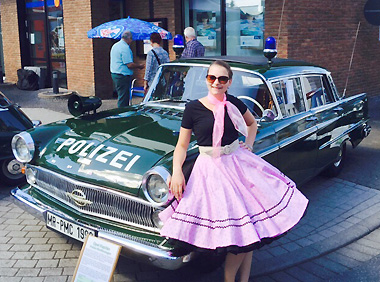 Petticoat-Dame vor dem Polizei Opel Kapitän bei den Golden Oldies