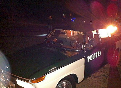 Die Schauspieler haben im Marburger Polizeifahrzeug, dem BMW 2000, Platz genommen, gleich geht es mit dem Dreh los