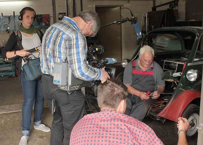 Erhard Ruppert wird mit der BMW-Isetta gefilmt, die derzeit repariert wird